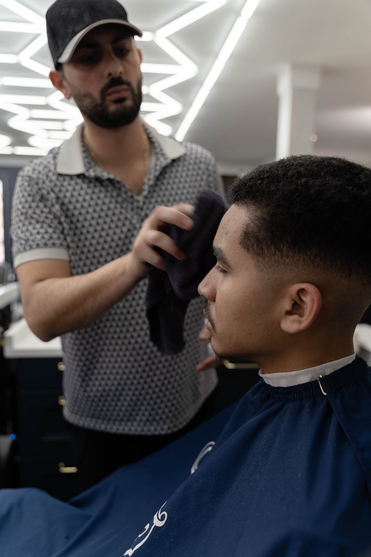 Master barber Edward finishing a precision fade haircut at Cherry Barbers barbershop Denver Colorado