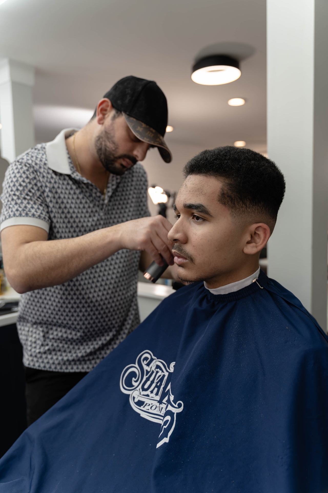 Barber performing precision lineup with clippers at Cherry Barbers barbershop Cherry Creek Denver Colorado